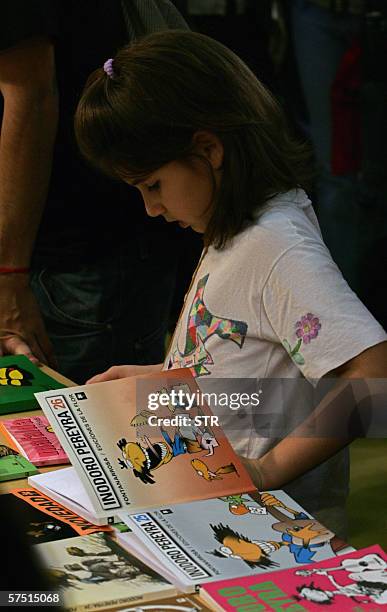 Buenos Aires, ARGENTINA: A child glances through Argentine writer and humorist Roberto Fontanarrosa comics while lines up to get an autograph at the...