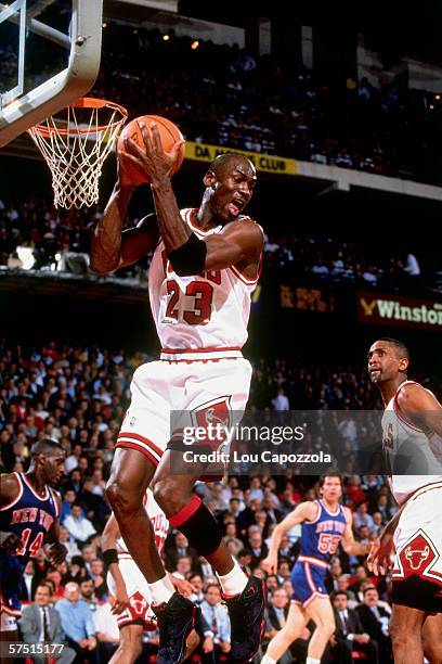 Michael Jordan of the Chicago Bulls grabs a rebound against the New York Knicks during an NBA game at Chicago Stadium in Chicago, Illinois in 1991....