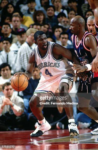 Michael Finley of the Dallas Mavericks makes his move against Clyde Drexler of the Houston Rockets on December 6, 1997 at the Palacio de los Deportes...