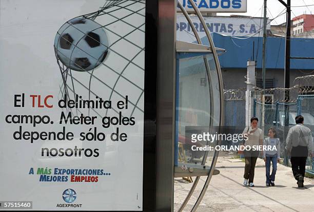 Una mujer y su hija caminan por una centrica avenida de Ciudad de Guatemala, el 02 de mayo de 2006, donde se anuncian mas empleos con la entrada en...