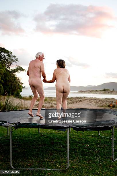 naked couple on trampoline - nu imagens e fotografias de stock