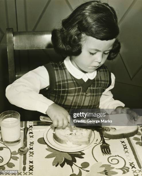 girl (4-5) spreading butter on slice of toast, (b&w) - 1940s cooking stock pictures, royalty-free photos & images