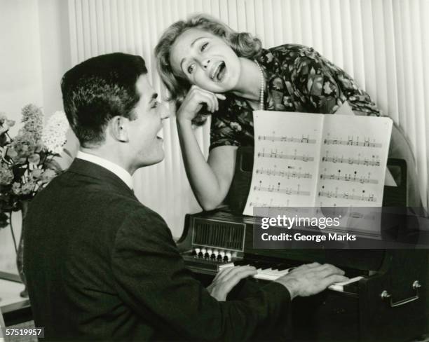 young couple singing, man playing piano, (b&w) - couple singing stock pictures, royalty-free photos & images