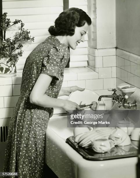 woman washing dishes at kitchen sink, (b&w) - 30 40 woman stockfoto's en -beelden