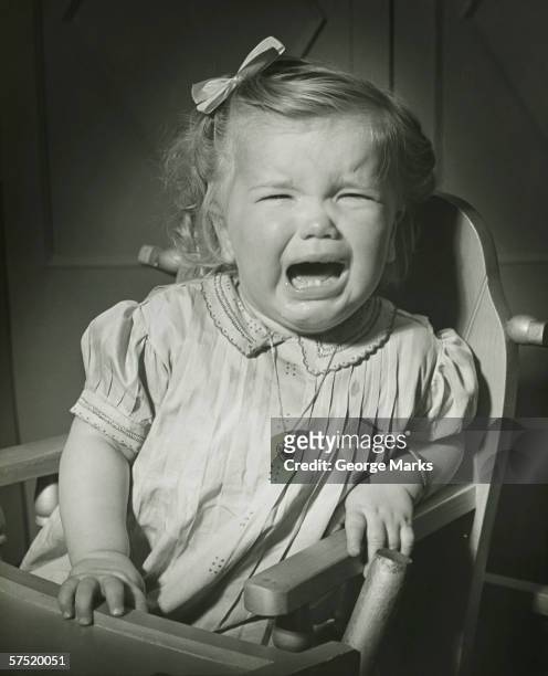 girl (18-24 months) crying, sitting in high chair, (b&w) - one baby girl only - fotografias e filmes do acervo