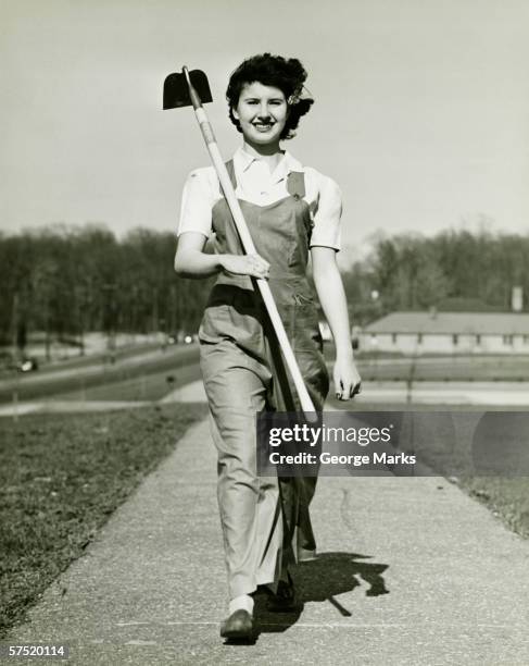 woman with hoe walking on path, (b&w), portrait - garden hoe stock pictures, royalty-free photos & images