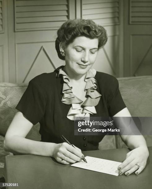 woman writing letter at desk, (b&w) - donna mezzo busto bianco e nero foto e immagini stock