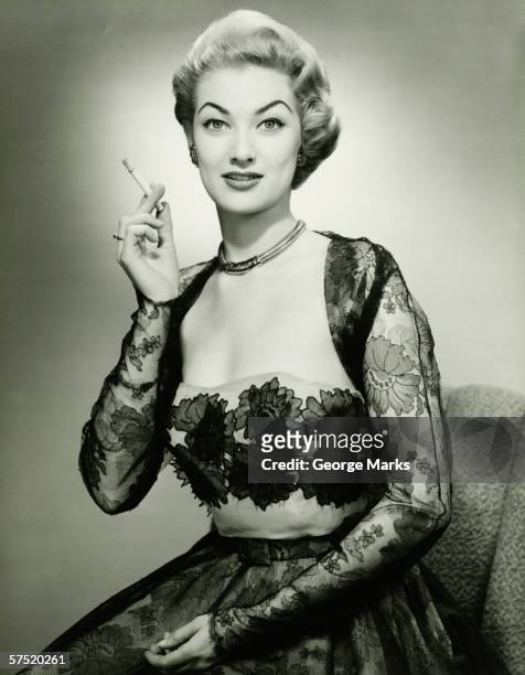 young woman wearing evening dress smoking cigarette, (b&w), portrait - beautiful women smoking cigarettes stockfoto's en -beelden