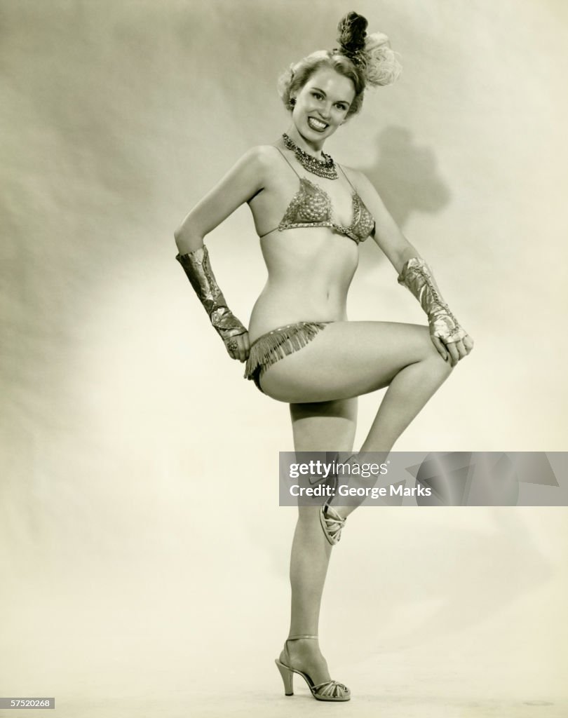 Young woman standing in show girl costume, (B&W)