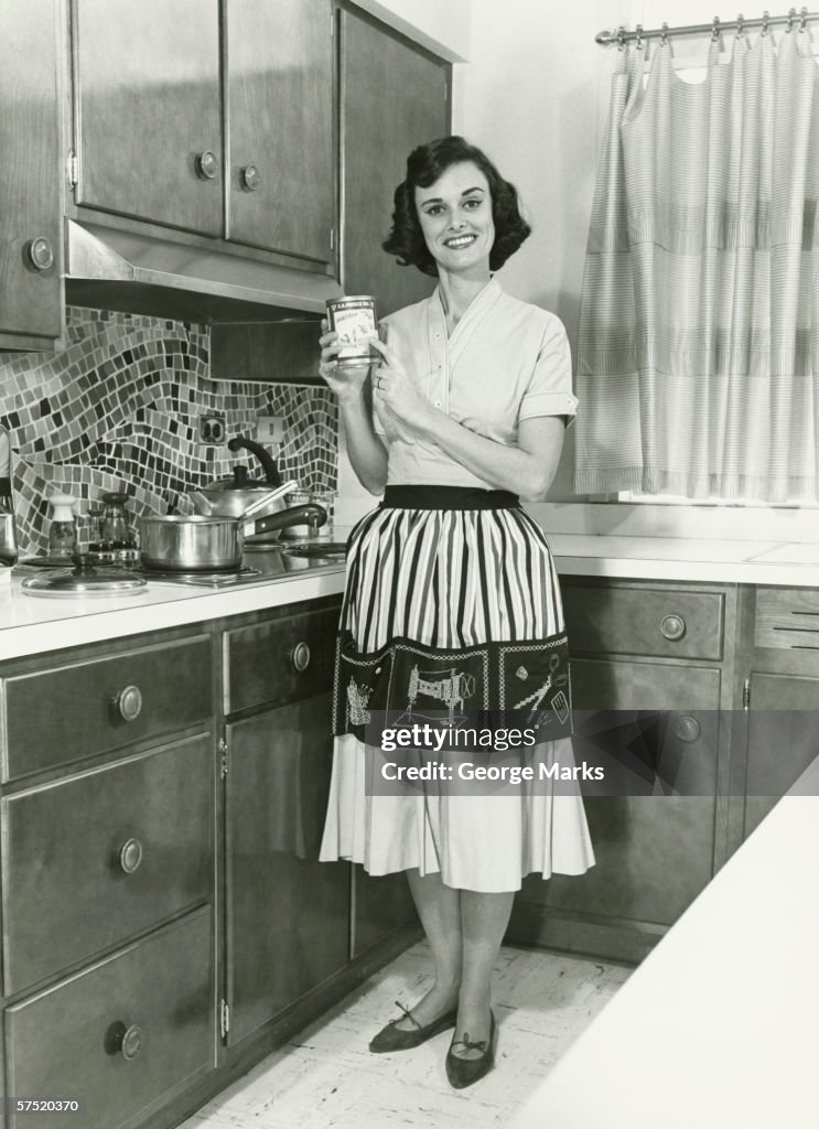 Woman posing in kitchen, (B&W), portrait