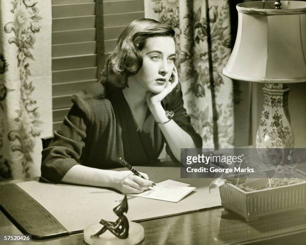 thoughtful woman writing letter at desk, (b&w) - correspondence 個照片及圖片檔
