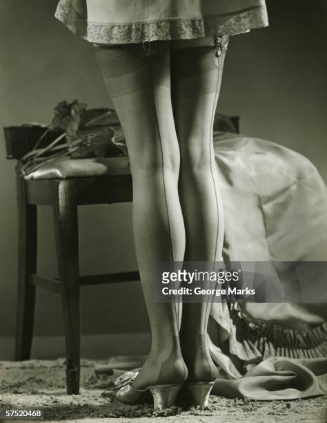 woman in stockings standing indoors, (b&w), low section - vintage nylon stockings stockfoto's en -beelden