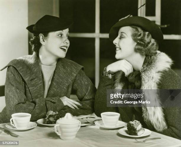 two young women chatting, having coffee and cake, (b&w) - 30 40 woman stockfoto's en -beelden