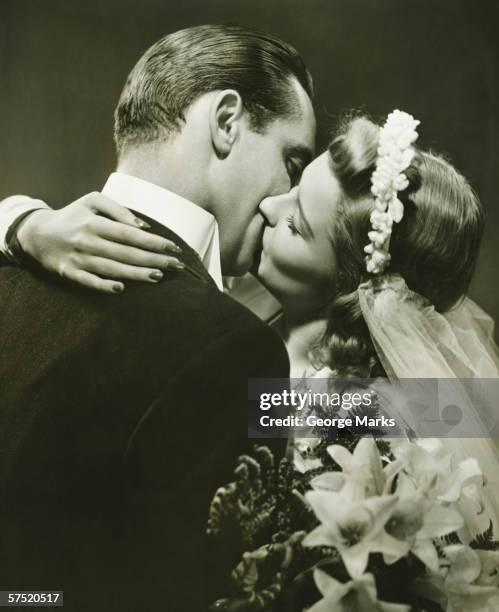 bride and groom kissing in studio, (b&w) - vintage wedding stock pictures, royalty-free photos & images