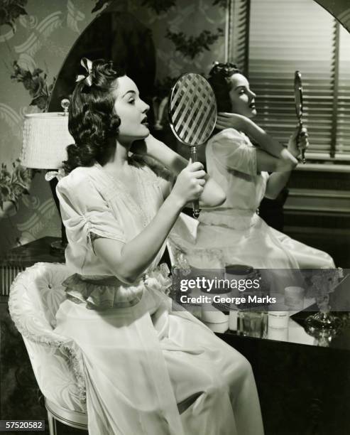 young woman examining make-up in mirror, (b&w) - vintage glamour stock pictures, royalty-free photos & images