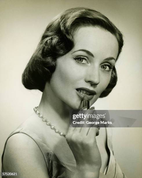 woman applying lipstick in studio, (b&w), portrait - lipstick stock pictures, royalty-free photos & images
