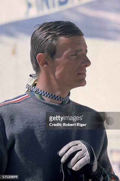 French professional downhill skier Jean-Claude Killy in profile as he wears a sweater and gloves with his goggles around his neck at a ski slope,...