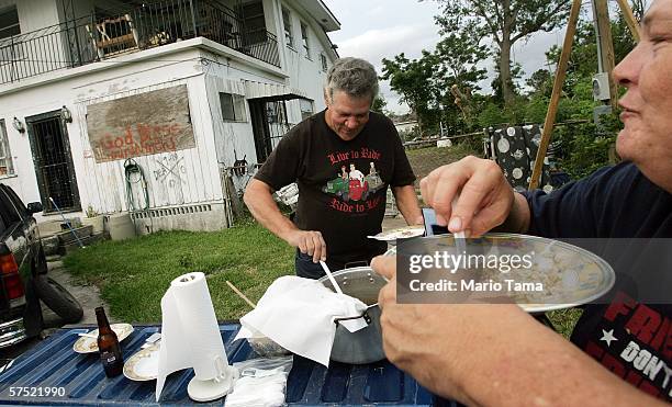 Former evacuees Paul and Patty Gadel eat gumbo in front of their damaged Lower Ninth Ward home May 2, 2006 in New Orleans, Louisiana. Gadel and his...