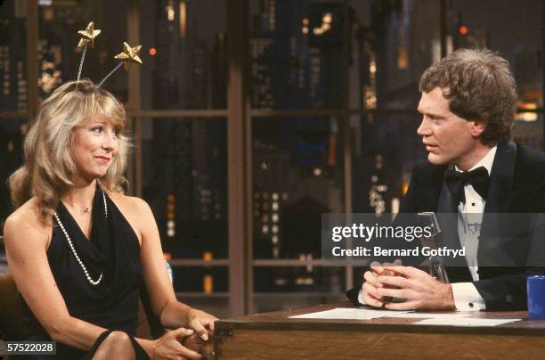 American actress Teri Garr sits and talks with tuxedo-clad talk show host David Letterman as she wears a formal gown and deely-boppers during an...