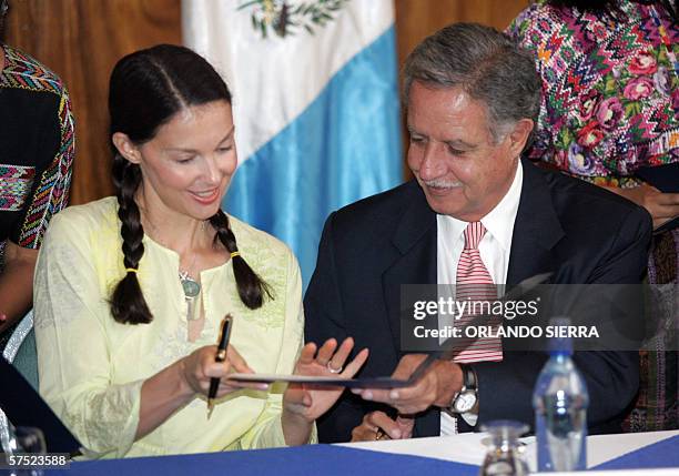 El presidente de Guatemala, Oscar Berger y la actriz astadounidense Asheley Judd, intercambian carpetas al firmar un acuerdo de cooperacion para el...