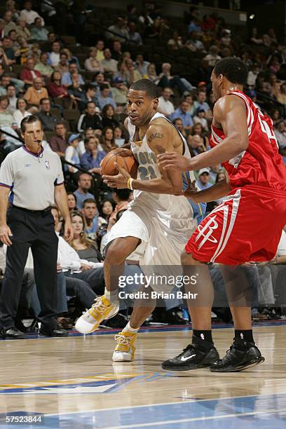 Marcus Camby of the Denver Nuggets drives around Chuck Hayes of the Houston Rockets on April 17, 2006 at the Pepsi Center in Denver, Colorado. The...