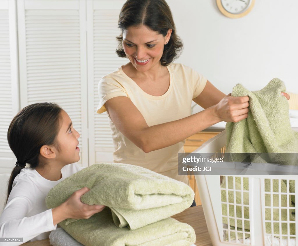 Mother and daughter folding laundry together