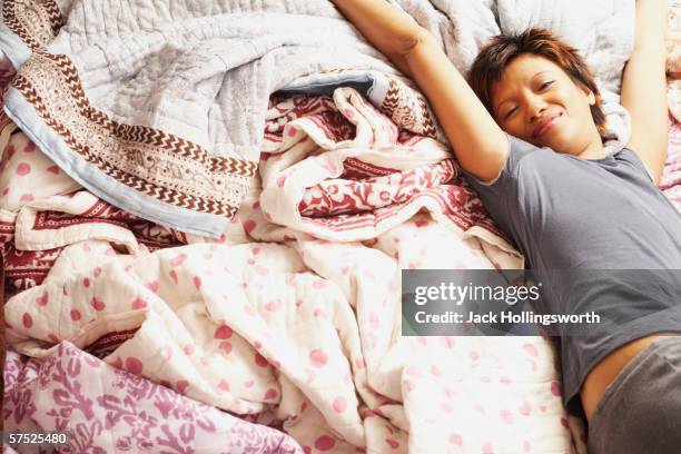 young woman stretching in bed - mid volwassen vrouw stockfoto's en -beelden