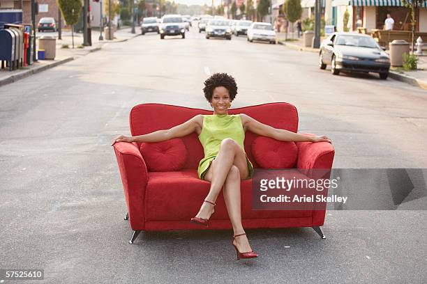 young woman sitting on a couch outdoors - auto sofa stock-fotos und bilder