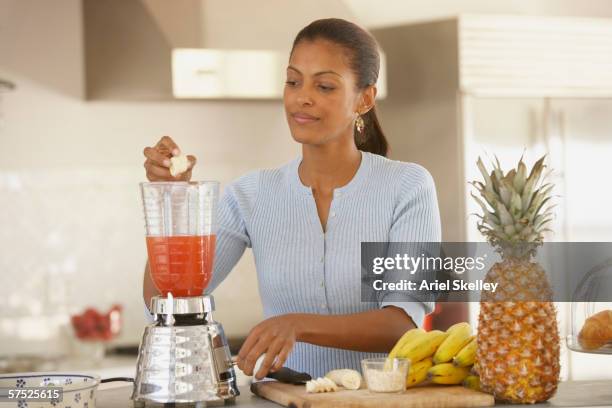 young woman making a smoothie - blender stock pictures, royalty-free photos & images