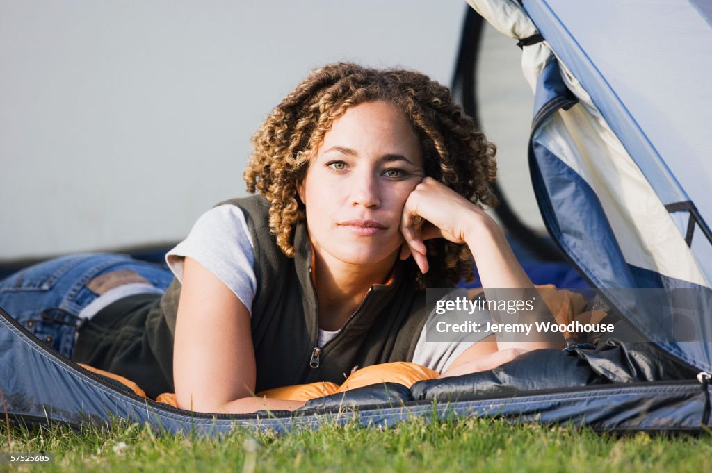 Young woman sitting in a tent outdoors