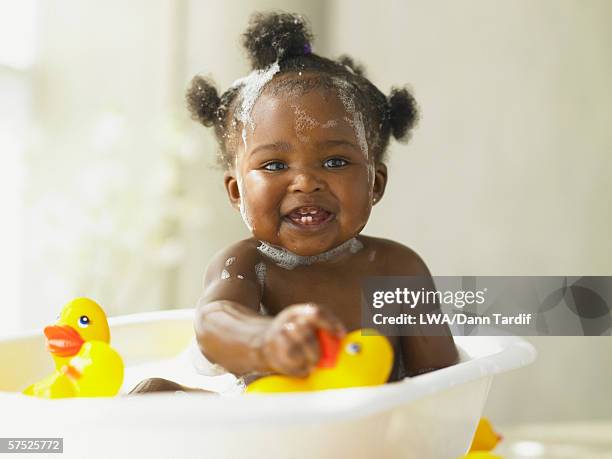 baby girl playing in the bathtub - african american girl photos et images de collection