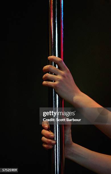 Woman performs pole tricks during a Polepeople pole dancing class May 3, 2006 in London, England. Since celebrities hailed pole dancing as the latest...