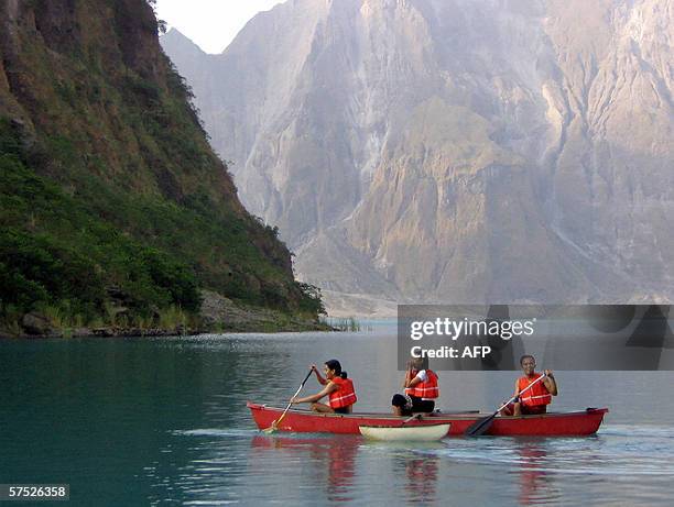 Local tourists use a kayak to explore the turquoise-colored crater lake of Mount Pinatubo volcano 29 April 2006. Life is rapidly returning to this...