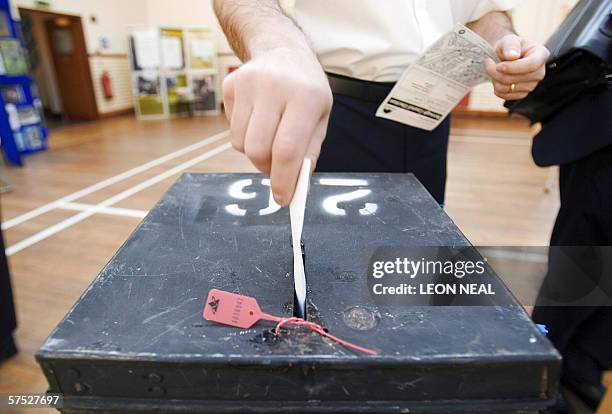 United Kingdom: A voter places his voting card in the ballot box at a polling station in Wandsworth, in south London, 04 May 2006, during the local...