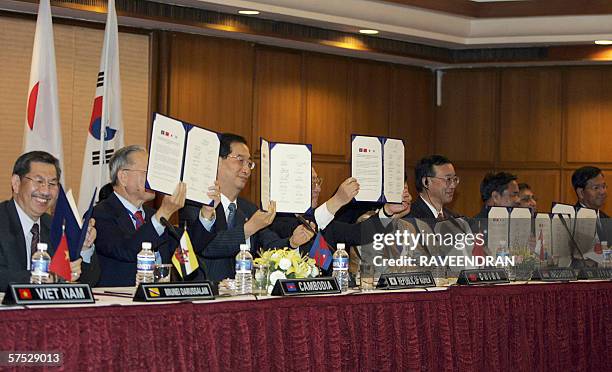 Finance Ministers of the 10-member ASEAN group along with their counterparts from China, Japan and Korea show documents after a signing ceremony in...