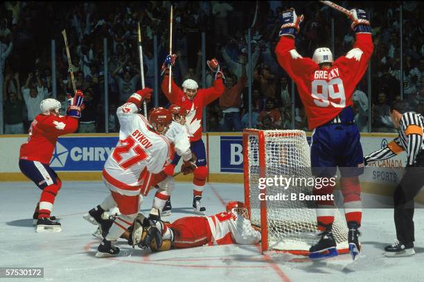 Mario Lemieux teammate Wayne Gretzky and Larry Murphy raise their sticks in the air and celebrate the game winning goal scored against Team Soviet...