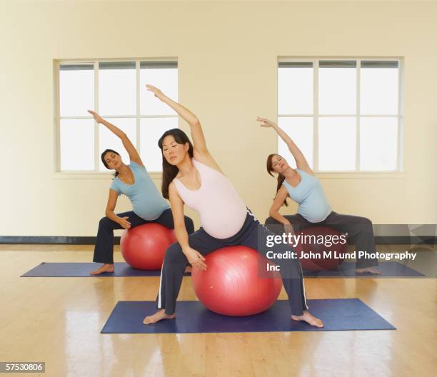 pregnant women stretching on exercise balls - antenatal class stock pictures, royalty-free photos & images