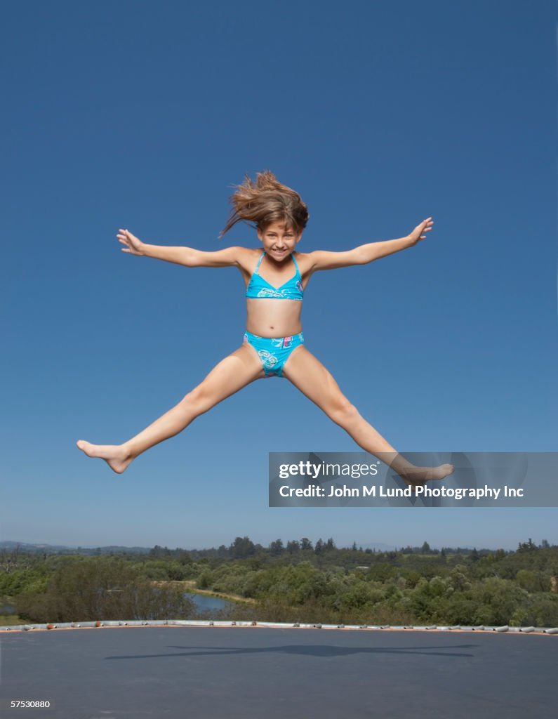 Young girl jumping on a trampoline