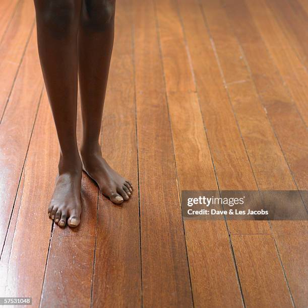 young woman's bare feet on a hardwood floor - african american woman barefoot stock pictures, royalty-free photos & images