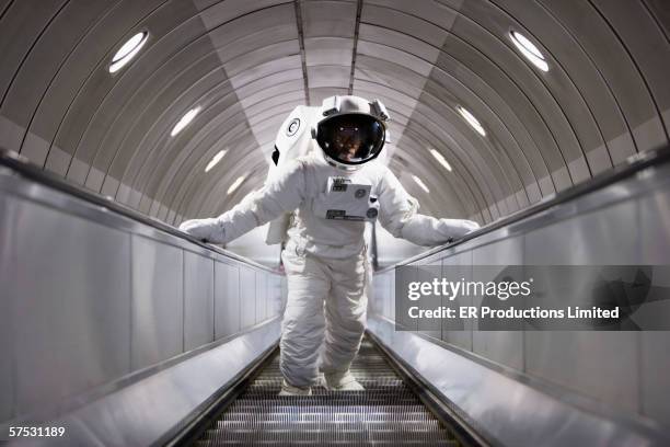 astronaut using an escalator - astronaut stock-fotos und bilder