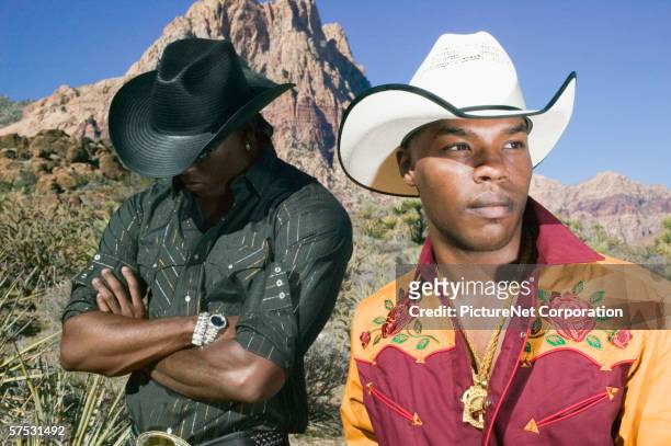 young men in cowboy outfits posing for the camera - cowboy hat stock pictures, royalty-free photos & images