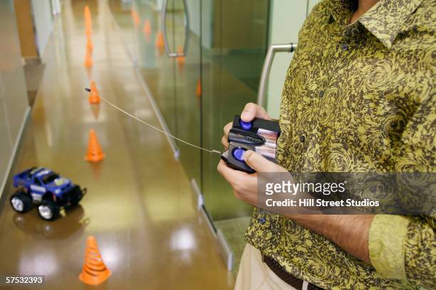 businessman playing with an rc car in the hallway - remote control car stock pictures, royalty-free photos & images