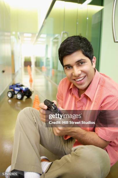 businessman playing with an rc car in the hallway - remote control car stock pictures, royalty-free photos & images