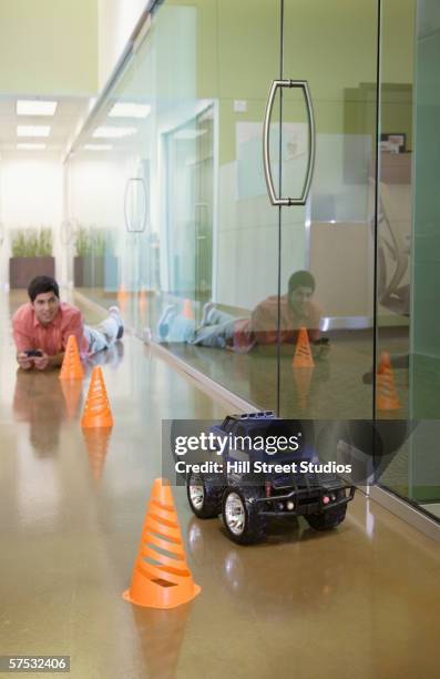 businessman playing with an rc car in the hallway - remote controlled car fotografías e imágenes de stock