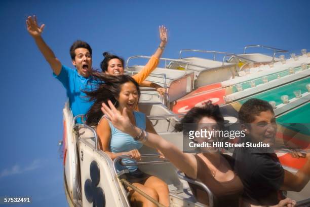 people riding a roller coaster - young woman screaming on a rollercoaster stock-fotos und bilder