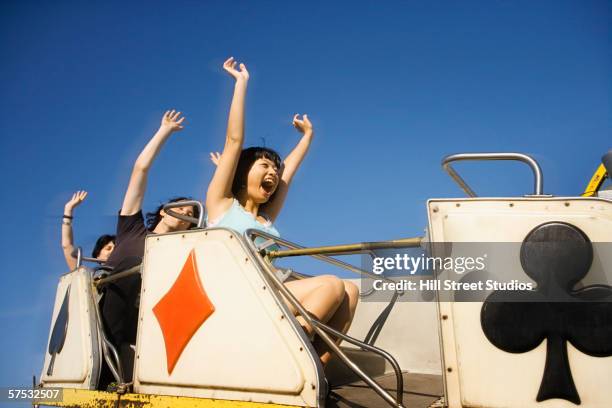 people riding a roller coaster - young woman screaming on a rollercoaster stock-fotos und bilder