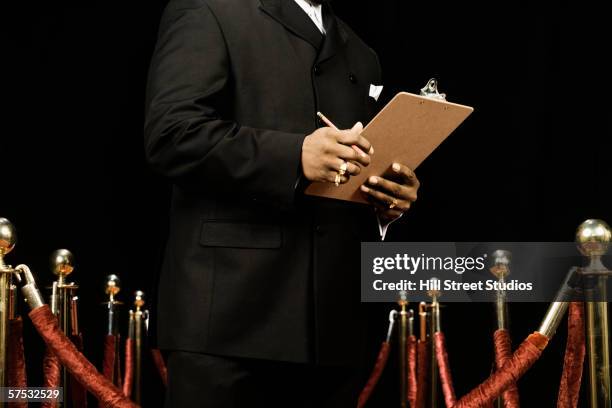 bouncer holding a guest list - bouncer stock pictures, royalty-free photos & images