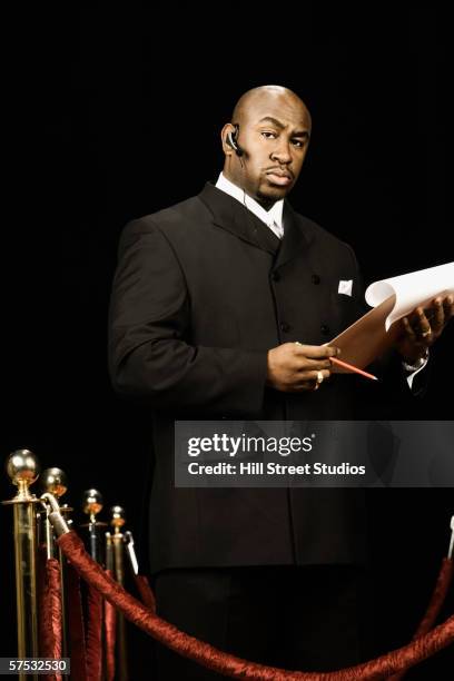 bouncer holding a guest list - bouncer stock pictures, royalty-free photos & images