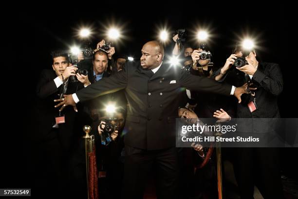 bouncer holding photographers back - paparazzi photographers stockfoto's en -beelden