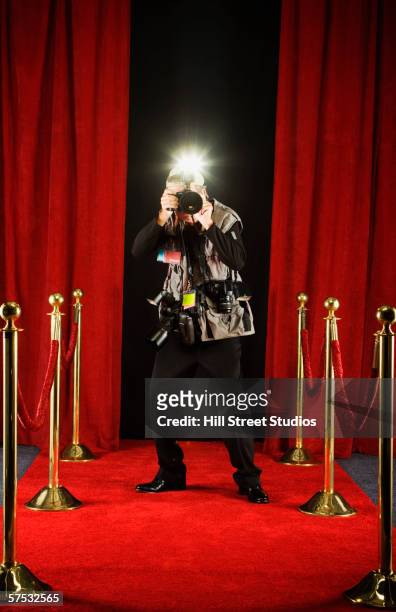 photographer taking a picture on the red carpet - paparazzi photographer stockfoto's en -beelden